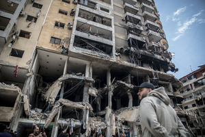 A man stands in front of a destroyed row of businesses in Beirut’s southern suburbs, known as Dahieyh, during a 10-day ceasefire between Israel and Hezbollah. After a 10-day ceasefire declared on April 16, 2026, displaced families in Lebanon began returning to assess widespread destruction from weeks of fighting that killed over 2,400 people. Many homes, hospitals, and key infrastructure were damaged, while more than one million people remain displaced. Despite the pause, access to some areas is restricted, and fears persist that fighting could resume.