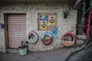 Pictures of fighters and decorative tires in the street in the village of Jibchit, Nabatieh district. After a 10-day ceasefire declared on April 16, 2026, displaced families in Lebanon began returning to assess widespread destruction from weeks of fighting that killed over 2,400 people. Many homes, hospitals, and key infrastructure were damaged, while more than one million people remain displaced. Despite the pause, access to some areas is restricted, and fears persist that fighting could resume.