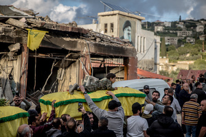 A young relative is carried on a coffin at a funeral for three children - Narges (8), Mohammed (11) and Zainab (15) - and their mother, Khadija, in Jibchit, Nabatieh district. The family were killed by an Israeli airstrike while displaced, relatives and neighbours said. Civilians killed in heavy bombardment were buried in a mass funeral in the village of Jibchit, southern Lebanon. Families returned during a temporary ceasefire to lay victims, many killed in earlier strikes, to rest after being unable to access the cemetery. Mourners carried coffins through the damaged village, reflecting the heavy civilian toll of the conflict.