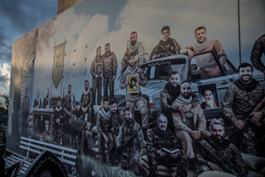 A poster of Hezbollah fighters at a cemetery in Jibchit, Nabatieh district. After a 10-day ceasefire declared on April 16, 2026, displaced families in Lebanon began returning to assess widespread destruction from weeks of fighting that killed over 2,400 people. Many homes, hospitals, and key infrastructure were damaged, while more than one million people remain displaced. Despite the pause, access to some areas is restricted, and fears persist that fighting could resume.
