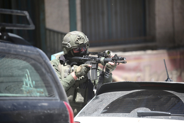 An Israeli soldier stands on guard during an army raid at a café in the Rafidia neighborhood of Nablus in the West Bank. The Israeli army stormed the café and arrested dozens of Palestinians. A Palestinian man in his twenties was killed during the operation.