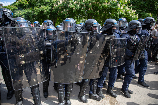 CRS (Compagnies Républicaines de Sécurité) police behind their shields during the Labour Day demonstration. The annual Labour Day march in Paris drew large crowds of demonstrators. While most marched peacefully, some groups clashed with police along the route. Officers used tear gas after objects were thrown, and several streets were temporarily blocked.