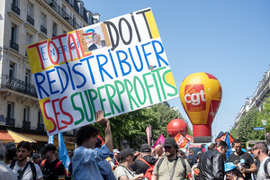 A protester holds a sign during the May Day demonstration in Paris. It says: "The Total Energies must redistribute it super profit." Tens of thousands of trade unionists and grassroots activists gathered in Paris to celebrate the achievements of the labor movement and raise awareness of workers’ rights.