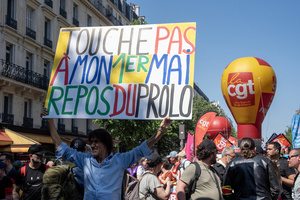 A protester holds a sign during the May Day demonstration in Paris. The sign says: "Don't touch the 1st of May. The working-class holiday." Tens of thousands of trade unionists and grassroots activists gathered in Paris to celebrate the achievements of the labor movement and raise awareness of workers’ rights.