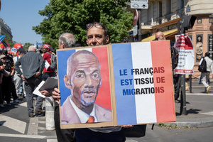 A protester holds a sign during the May Day demonstration in Paris. The sign says: "France is a diverse of communities." Tens of thousands of trade unionists and grassroots activists gathered in Paris to celebrate the achievements of the labor movement and raise awareness of workers’ rights.