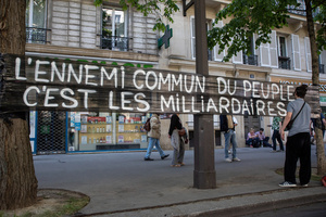 A protester writes a message on the black foil during the May Day demonstration in Paris. The message says: "The enemies of the common people are the millionaires." Tens of thousands of trade unionists and grassroots activists gathered in Paris to celebrate the achievements of the labor movement and raise awareness of workers’ rights.