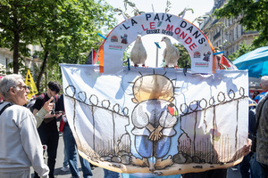 A protester hold a sign with two doves during the May Day demonstration in Paris. The sign says: "Peace in the world!" Tens of thousands of trade unionists and grassroots activists gathered in Paris to celebrate the achievements of the labor movement and raise awareness of workers’ rights.