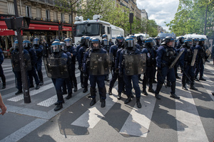 Riot police stand front of the water cannon truck before they charge during the May Day demonstration in Paris. Tens of thousands of trade unionists and grassroots activists gathered in Paris to celebrate the achievements of the labor movement and raise awareness of workers’ rights.