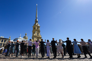 Young men and women in elegant dresses and suits perform a mass dance on Cathedral Square against the backdrop of the Peter and Paul Cathedral spire during the "Victory Ball". A large-scale theatrical reconstruction and flash mob titled "Victory Ball" (Bal Pobedy) takes place on the Cathedral Square of the Peter and Paul Fortress. The event is dedicated to the 81st anniversary of the victory in World War II (WWII). Hundreds of participants, including youth activists, members of the Yunarmia movement, and students in historical and modern military uniforms, perform mass dances and formations. The reconstruction is part of the city-wide celebrations ahead of Victory Day in St. Petersburg.