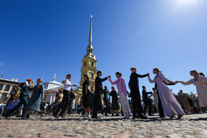 Young men and women in elegant dresses and suits perform a mass dance on Cathedral Square against the backdrop of the Peter and Paul Cathedral spire during the "Victory Ball". A large-scale theatrical reconstruction and flash mob titled "Victory Ball" (Bal Pobedy) takes place on the Cathedral Square of the Peter and Paul Fortress. The event is dedicated to the 81st anniversary of the victory in World War II (WWII). Hundreds of participants, including youth activists, members of the Yunarmia movement, and students in historical and modern military uniforms, perform mass dances and formations. The reconstruction is part of the city-wide celebrations ahead of Victory Day in St. Petersburg.