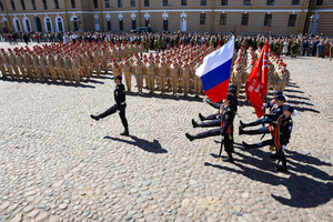 A ceremonial group carries the National Flag of Russia and the Victory Banner across Cathedral Square during the opening of the "Victory Ball" reconstruction. A large-scale theatrical reconstruction and flash mob titled "Victory Ball" (Bal Pobedy) takes place on the Cathedral Square of the Peter and Paul Fortress. The event is dedicated to the 81st anniversary of the victory in World War II (WWII). Hundreds of participants, including youth activists, members of the Yunarmia movement, and students in historical and modern military uniforms, perform mass dances and formations. The reconstruction is part of the city-wide celebrations ahead of Victory Day in St. Petersburg.
