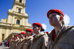 A close-up of a young woman from the Yunarmia youth movement in a red beret standing in formation during the "Victory Ball" at the Peter and Paul Fortress. A large-scale theatrical reconstruction and flash mob titled "Victory Ball" (Bal Pobedy) takes place on the Cathedral Square of the Peter and Paul Fortress. The event is dedicated to the 81st anniversary of the victory in World War II (WWII). Hundreds of participants, including youth activists, members of the Yunarmia movement, and students in historical and modern military uniforms, perform mass dances and formations. The reconstruction is part of the city-wide celebrations ahead of Victory Day in St. Petersburg.