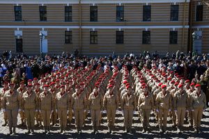 A large group of the Yunarmia youth movement members in signature red berets standing in formation during a festive flash mob at the Peter and Paul Fortress. A large-scale theatrical reconstruction and flash mob titled "Victory Ball" (Bal Pobedy) takes place on the Cathedral Square of the Peter and Paul Fortress. The event is dedicated to the 81st anniversary of the victory in World War II (WWII). Hundreds of participants, including youth activists, members of the Yunarmia movement, and students in historical and modern military uniforms, perform mass dances and formations. The reconstruction is part of the city-wide celebrations ahead of Victory Day in St. Petersburg.