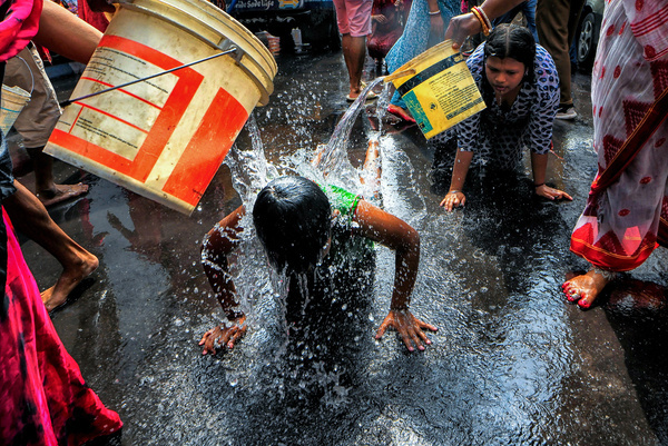 A child seen lying on the ground while devotees pour water on him during the traditional ritual worship of Devi Sheetala. In Hindu mythology the Godess Devi sheetala is revered as a deity of healing, protection, and purification, often worshipped to cure poxes, sores, and diseases. Devotees worship her on Tuesdays and on special days like Sheetala Ashtami (or Basoda), often offering cold food and engaging in cleansing rituals as well as doing different traditional practices like Dandi (Lying on Ground).