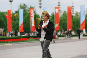 A woman wearing St. George ribbons is seen walking while using a phone during the celebration of Victory Day at the Exhibition of Achievements of the National Economy (VDNKh) Moscow marked the 81st anniversary of the Soviet victory over Nazi Germany on May 9 with commemorative events across the city honoring those who fought in World War II. Some residents took part in memorial activities remembering the wartime generation.