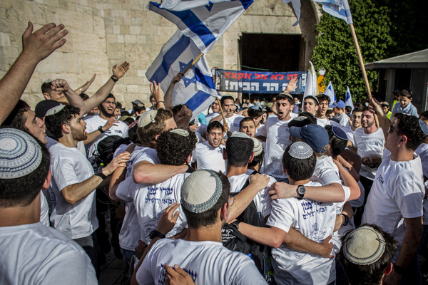 Israeli right wing youths wave their national flags outside Damascus gate In Jerusalem. Israeli nationalists, many of them teenagers and young adults, swept through the narrow streets of Jerusalem's Old City during the annual Jerusalem Day march, chanting Death to Arabs and May your villages burn as tens of thousands paraded to celebrate what Israeli authorities call the reunification of Jerusalem following Israel's capture and annexation of east Jerusalem in the 1967 Arab-Israeli war, while many Palestinian residents remained barricaded indoors and shopkeepers were forced, ostensibly for their own protection, to close their businesses.