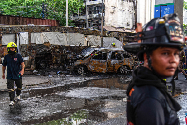 Rescue workers seen working at the accident site where a cargo train crashed with a public bus at the Makkasan airport rail link station. At least 8 people were killed and more than 25 people injured in the accident.