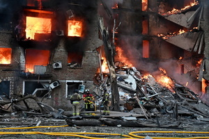 Firefighters work at the scene of a fire in a destroyed apartment building as a result of a Russian missile attack. A large ballistic missile attack pounded Kyiv early on May 24, authorities said, wounding at least five people after Moscow threatened retaliation for strikes in Russian-occupied eastern Ukraine.
