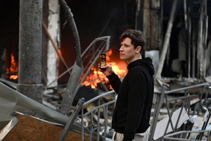 A man takes a photo of a fire in a heavily damaged building after Russian strikes in Kyiv. A large ballistic missile attack pounded Kyiv early on May 24, authorities said, wounding at least five people after Moscow threatened retaliation for strikes in Russian-occupied eastern Ukraine.