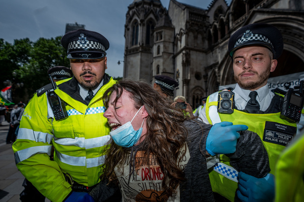 A Palestine Action supporter is arrested under the Terrorism Act for holding up signs in support of the proscribed group during the protest. The High Court judge has ruled that the proscription of Palestine Action is lawful and is to be upheld. Consequently supporters of the proscribed action group were arrested en masse outside the Royal Courts of Justice in London.