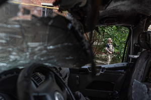 A police officer seen standing next to a van damaged by a drone during the evacuation of civilians by the Ukrainian police unit ‘White Angels’ .
