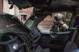 A police officer seen standing next to a van damaged by a drone during the evacuation of civilians by the Ukrainian police unit ‘White Angels’ .