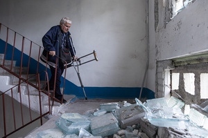 A man seen walking down the stairs of his home which has been damaged by Russian shelling during the evacuation of civilians by the ‘White Angels’ police unit.