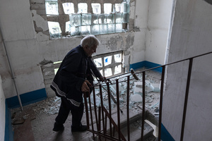 A man seen walking down the stairs of his home which has been damaged by Russian shelling during the evacuation of civilians by the ‘White Angels’ police unit.