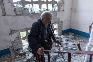 A man seen walking down the stairs of his home which has been damaged by Russian shelling during the evacuation of civilians by the ‘White Angels’ police unit.
