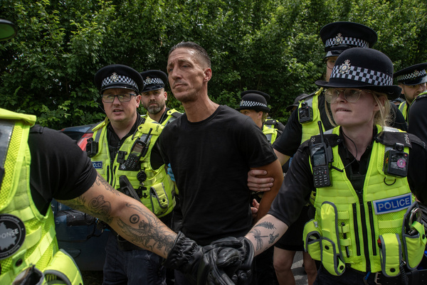 Police officers escort an arrestee away during a demonstration outside the MBR Acre breeding facilities in Huntingdon. Hundreds of animal rights activists gathered outside the MBR Acres site in Huntingdon, Cambridgeshire, England. MBR Acres site is a beagle dog breeding facility. The Home Office has granted licence to harvest and sell blood, internal organs and other body fluids from puppies. Activists demand to close the site, stop animal testing and free the beagles from the cages.