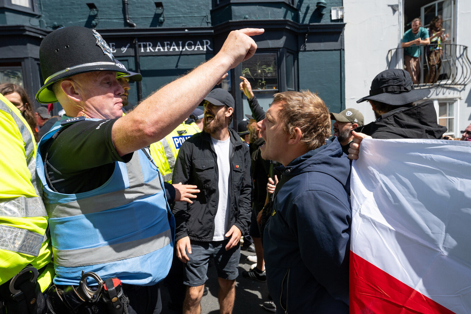 Anti-immigration protester faces off with police . Anti-immigration protesters gathered in Brighton city centre for a demonstration calling for stricter border controls, stronger enforcement of immigration laws and the deportation of illegal immigrants. The rally was met by thousands of counter protesters from anti-racist and anti-fascist groups taking part in a “Carnival Against Fascism” demonstration. Police maintained a large presence to separate the opposing groups as tensions flare.