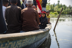 A Shia Muslim girl looks on while aboard a traditional boat during a Muharram procession on Dal Lake, commemorating the martyrdom of Imam Hussain and his companions in the Battle of Karbala. Muharram is the first month of the Islamic calendar. Shia Muslims observe Muharram as a period of mourning to commemorate the martyrdom of Imam Hussain, the grandson of Prophet Muhammad. Imam Hussain was martyred on the 10th day of Muharram, during the historic Battle of Karbala in 680 CE.