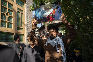 A Shia Muslim man walks while carrying photograph of Ayatollah Ali Khamenei and Mojtaba Khamenei during a Muharram procession commemorating the martyrdom of Imam Hussain and his companions in the Battle of Karbala. Muharram is the first month of the Islamic calendar. Shia Muslims observe Muharram as a period of mourning to commemorate the martyrdom of Imam Hussain, the grandson of Prophet Muhammad. Imam Hussain was martyred on the 10th day of Muharram, during the historic Battle of Karbala in 680 CE.