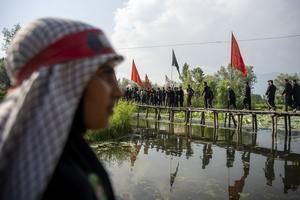 Shia Muslim mourners walk across a wooden bridge over Dal Lake during a Muharram procession commemorating the martyrdom of Imam Hussain and his companions in the Battle of Karbala. The procession forms part of annual mourning observances during the Islamic month of Muharram. Muharram is the first month of the Islamic calendar. Shia Muslims observe Muharram as a period of mourning to commemorate the martyrdom of Imam Hussain, the grandson of Prophet Muhammad. Imam Hussain was martyred on the 10th day of Muharram, during the historic Battle of Karbala in 680 CE.