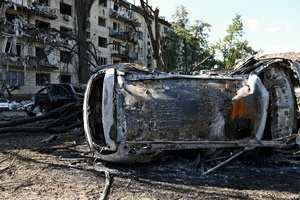 A burnt-out car near a damaged residential building as a result of a missile strike. Following a devastating overnight bombardment in which Russia launched 74 missiles and 496 attack drones, Kyiv has declared July 3, 2026, a city-wide Day of Mourning to honor the victims. At least 25 people were killed and over 80 injured across the capital as direct strikes heavily damaged residential apartment blocks, leaving active search and rescue operations scrambling to locate residents still believed to be trapped under the rubble.