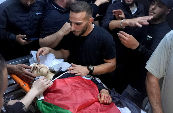 (EDITORS NOTE: Image depicts death)
Palestinians relatives and friends of 16-year-old Walid Abu Sneineh, weep over his body during his funeral at the Qalandiya refugee camp near Ramallah in the West Bank. Abu Sneineh was killed by Israeli army fire during the stone-throwing clashes that erupted during a military raid on the neighborhoods in the Qalandiya camp in the central West Bank.