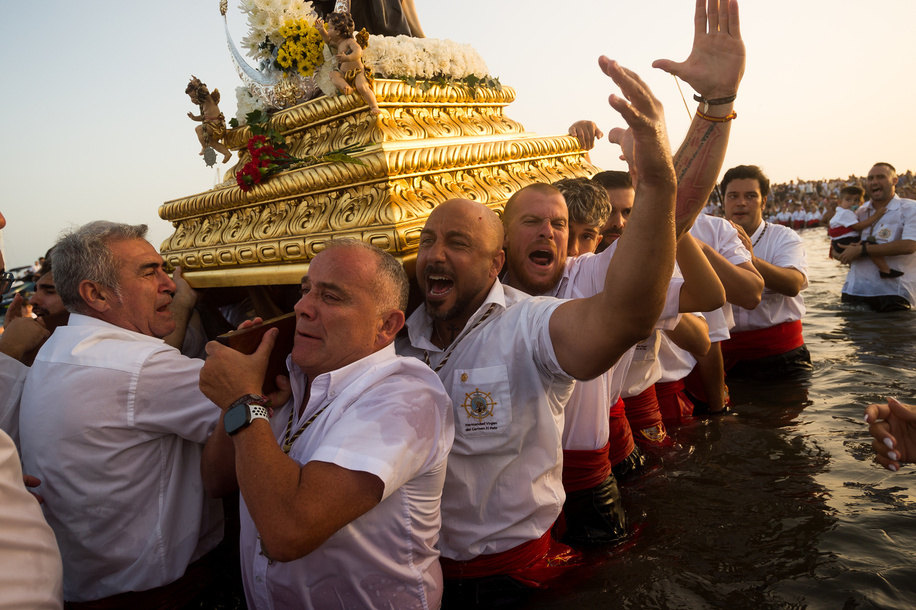 Penitents of 'Virgen del Carmen' brotherhood are seen shouting as they take part in a procession at a beach. The annual 'Virgen del Carmen' festivity in Málaga City, held on 16 July, celebrates the patron saint of sailors and fishermen. The statue of the Virgin is carried by a group of believers in traditional costume along the streets before being placed on a boat from a beach, which later sails down the Málaga coast.