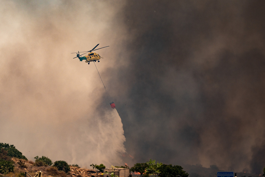 A firefighting helicopter drops water while battling the Los Gallardos wildfire in Almeria. Wildfire in the municipalities of Los Gallardos and Bedar, Almeria province, southern Spain. According to the latest official reports, at least, 12 people have been killed and 23 remain missing. The fire has burned approximately 3200 hectares.