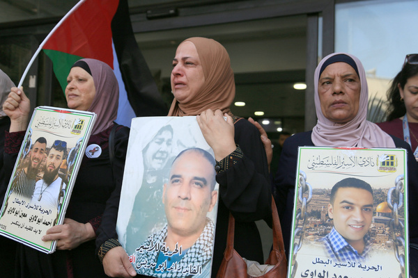 Palestinian seen holding pictures of Palestinian prisoners during a solidarity march demanding the release from Israeli prisons. A Palestinian source reported that the number of Palestinian prisoners in Israeli jails have exceeded 9,600.