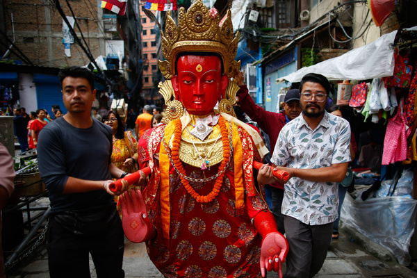 Devotees carry a centuries-old Buddhist idol towards a prayer site to offer Panchadana and take part in the grand procession of Dipankara Buddha during the Samyak Mahadan, one of the Newar Buddhist community's most sacred festivals.