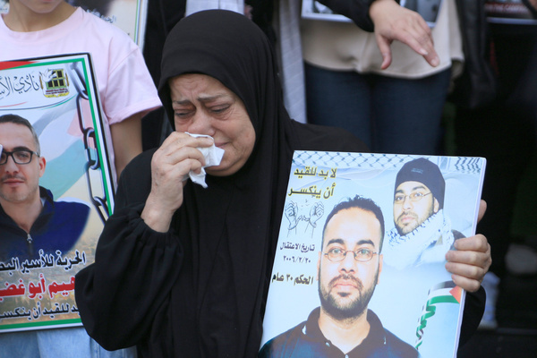 A Palestinian mother weeps as she holds a picture of her son imprisoned in an Israeli jail, pleading for his release during a march through the streets coinciding with Palestinian Prisoners' Day.