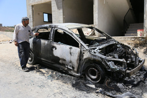 A Palestinian man inspects a burned-out car after an attack by Jewish settlers on Palestinian homes. Jewish settlers set fire to cars, threw stones at homes, and wrote Hebrew slogans on houses in Jalud village, south of Nablus in the West Bank. They also damaged power lines between the villages of Jalud and Telfit, near Nablus in the West Bank.