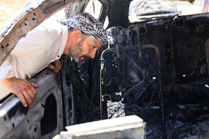 A Palestinian man inspects burned-out car after an attack by Jewish settlers on Palestinian homes. Jewish settlers set fire to cars, threw stones at homes, and wrote Hebrew slogans on houses in Jalud village, south of Nablus in the West Bank. They also damaged power lines between the villages of Jalud and Telfit, near Nablus in the West Bank.
