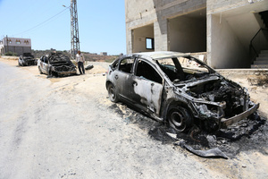 A Palestinian man inspects burned-out cars after an attack by Jewish settlers on Palestinian homes. Jewish settlers set fire to cars, threw stones at homes, and wrote Hebrew slogans on houses in Jalud village, south of Nablus in the West Bank. They also damaged power lines between the villages of Jalud and Telfit, near Nablus in the West Bank.