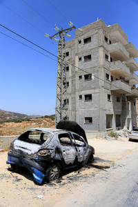General view of burned-out car along the street after an attack by Jewish settlers on Palestinian homes. Jewish settlers set fire to cars, threw stones at homes, and wrote Hebrew slogans on houses in Jalud village, south of Nablus in the West Bank. They also damaged power lines between the villages of Jalud and Telfit, near Nablus in the West Bank.