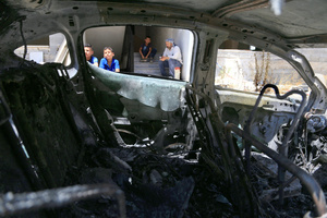Palestinian children look at the burned-out car after an attack by Jewish settlers on Palestinian homes. Jewish settlers set fire to cars, threw stones at homes, and wrote Hebrew slogans on houses in Jalud village, south of Nablus in the West Bank. They also damaged power lines between the villages of Jalud and Telfit, near Nablus in the West Bank.
