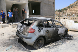 Palestinians look at the burned-out car after an attack by Jewish settlers on Palestinian homes. Jewish settlers set fire to cars, threw stones at homes, and wrote Hebrew slogans on houses in Jalud village, south of Nablus in the West Bank. They also damaged power lines between the villages of Jalud and Telfit, near Nablus in the West Bank.