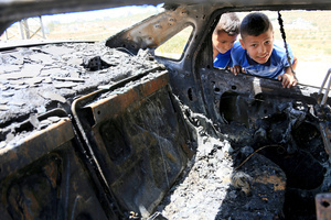 Palestinian children inspect the burned-out car after an attack by Jewish settlers on Palestinian homes. Jewish settlers set fire to cars, threw stones at homes, and wrote Hebrew slogans on houses in Jalud village, south of Nablus in the West Bank. They also damaged power lines between the villages of Jalud and Telfit, near Nablus in the West Bank.