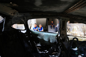 Palestinian children look at a burned-out car after an attack by Jewish settlers on Palestinian homes. Jewish settlers set fire to cars, threw stones at homes, and wrote Hebrew slogans on houses in Jalud village, south of Nablus in the West Bank. They also damaged power lines between the villages of Jalud and Telfit, near Nablus in the West Bank.