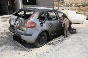 A Palestinian child inspects the burned-out car after an attack by Jewish settlers on Palestinian homes. Jewish settlers set fire to cars, threw stones at homes, and wrote Hebrew slogans on houses in Jalud village, south of Nablus in the West Bank. They also damaged power lines between the villages of Jalud and Telfit, near Nablus in the West Bank.